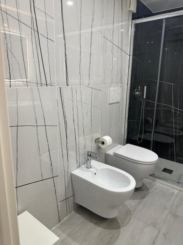 a white bathroom with a toilet and a sink at Saxlafenice in Bari