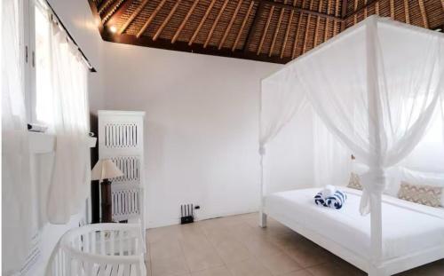 a bedroom with a white bed with a canopy at Steps to Canggu Beach Six Bedrooms, Five Baths in Denpasar