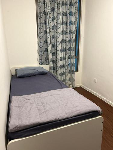 Una cama pequeña en una habitación con ventana. en Ella Residence Homestay, en Brinchang