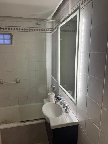 a bathroom with a sink and a mirror and a tub at Mariu Apartment in Buenos Aires