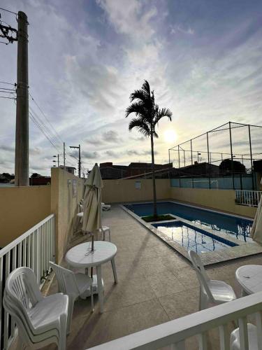 a patio with a table and chairs next to a pool at Apartamento próximo a Orla de Atalaia in Aracaju