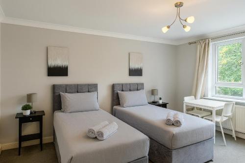 a bedroom with two beds and a desk and a window at Modern 2-Bedroom London Base - 15 mins to Central London - Next to East Croydon Station - Sleeps 5 in Croydon