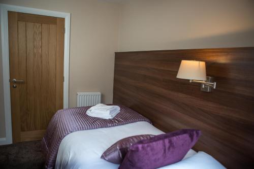 a hotel room with a bed with purple pillows at Foundry 34 in Penrith