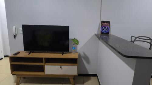 a tv sitting on top of a wooden dresser with a television at kitnet HAKUNA MATATA in Barão de Cocais