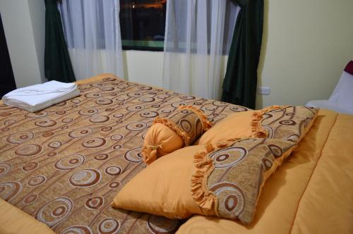 a bed with pillows on it in a bedroom at Balcones del Río Hotel in Latacunga