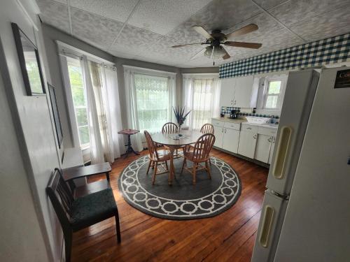 a kitchen with a table and chairs and a ceiling fan at The White Birch Inn in Berwick