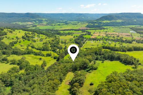 an overhead view of a green field with a circle in the sky at Wombat Wallows in Kangaroo Valley