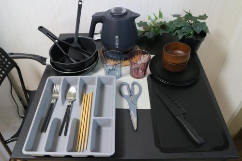 a table with a tray with utensils on it at お宿あびこシルバーハイツ in Osaka
