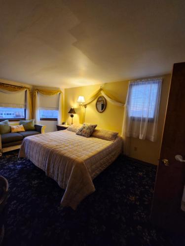 a bedroom with a large bed and a couch at The White Birch Inn in Berwick
