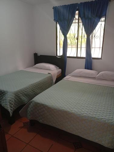 two beds in a room with a window at FINCA Villa luna in Quimbaya