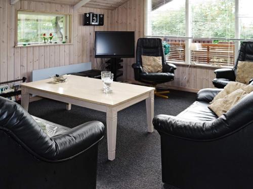 a living room with couches and a table and a tv at 6 person holiday home in Storvorde-By Traum in Storvorde
