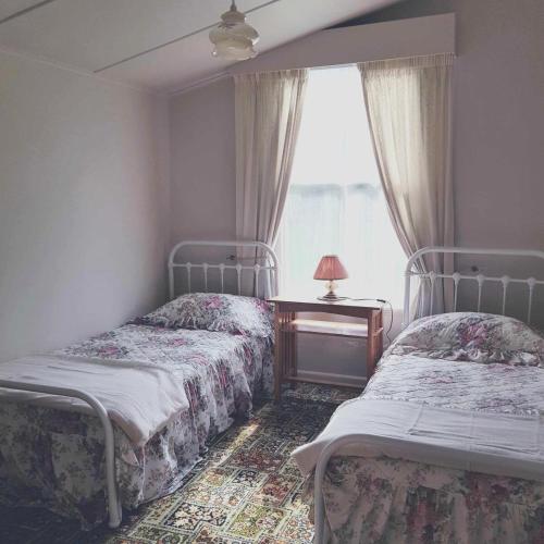 two beds in a room with a window at Little Rose Cottage in Rotherham