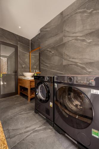 a washer and dryer in a bathroom with a sink at Sora Villa, 4BDR, Large Pool & Elevator Access in Da Nang