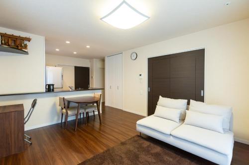 a living room with a white couch and a table at The Hana-Koganei Retreat & Home Stay in Kodaira