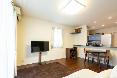 a living room with a tv and a table at The Hana-Koganei Retreat & Home Stay in Kodaira