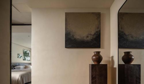 a room with two vases on a wall with a bed at Seven Letters · Zhanyue Hotel in Xijiang