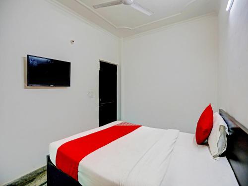 a white bedroom with a red and white bed at Hotel O Sunrise Villa in New Delhi