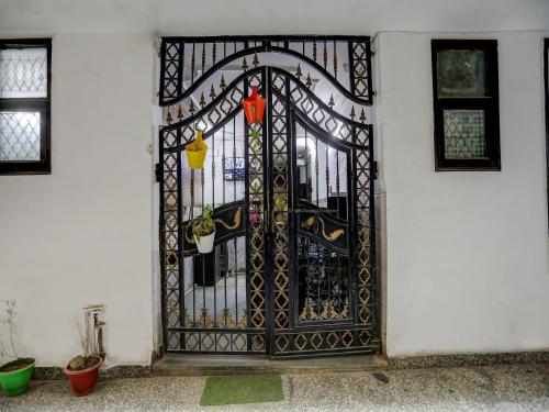 a gate in a white building with plants on it at Hotel O Sunrise Villa in New Delhi
