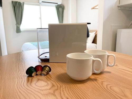 a table with two coffee mugs on top of it at Liaison Apartment Shinsaibashi in Osaka