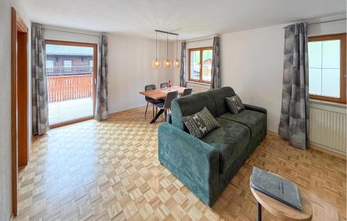 ein Wohnzimmer mit einer grünen Couch und einem Tisch in der Unterkunft Lovely Apartment In Klösterle With Wifi in Klösterle am Arlberg