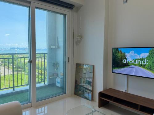 a living room with a large window and a tv at Grape Residence Hotel in Incheon