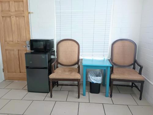 two chairs and a table with a blue table and a microwave at Oceana Boutique Hotel in San Clemente