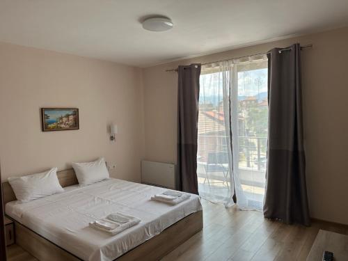 a bedroom with a bed and a large window at The Hillside Villa in Ognyanovo