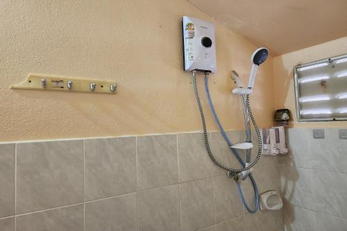 a shower in a bathroom with a blow dryer on the wall at My Pumpkin Bungalow Krabi in Krabi town