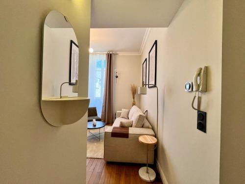un soggiorno con un divano e uno specchio di La Suite Ambiance chambre d hotel Cosy a Orléans