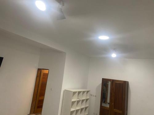 a room with two lights on the ceiling and a door at L'hospitalité in Darou Rhamane