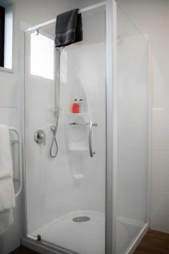 a shower with a glass door in a bathroom at Carrick Lodge Motel in Cromwell