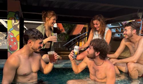 a group of people sitting in a swimming pool at Greengos Hotel in Lanquín