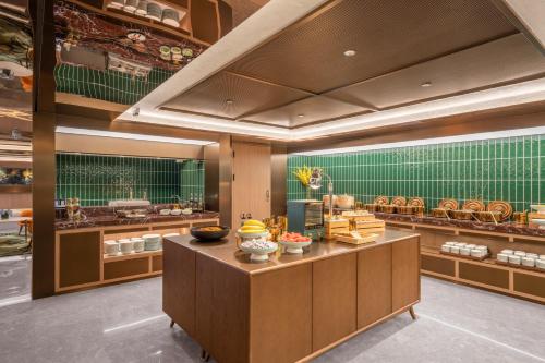 a restaurant with a counter with food on display at Orange Hotel Beijing Xi'erqi in Beijing