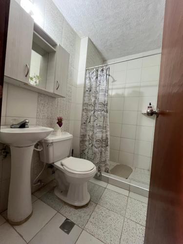a bathroom with a toilet and a sink and a shower at Apartamento Aeropuerto Maiquetia en Planta Baja in Catia La Mar