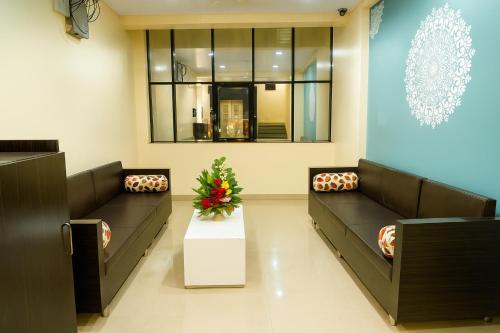 a waiting room with couches and a table with flowers at Hotel Avon International in Aurangabad