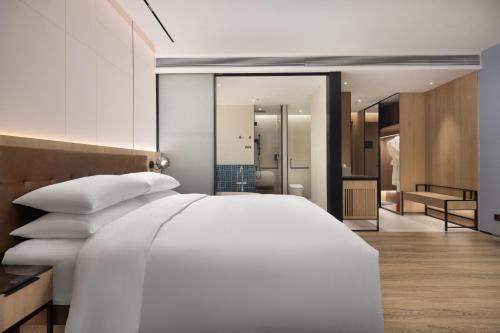 a bedroom with a white bed and a bathroom at Four Points by Sheraton Huzhou in Huzhou
