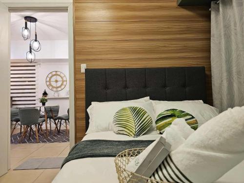 a bedroom with a large bed with a wooden headboard at RDC Cozy Suite in Tagaytay