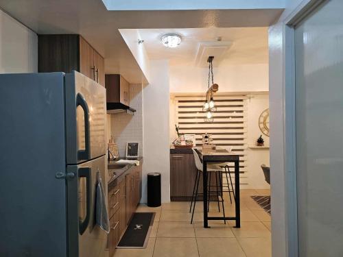 a kitchen with a refrigerator and a table in it at RDC Cozy Suite in Tagaytay