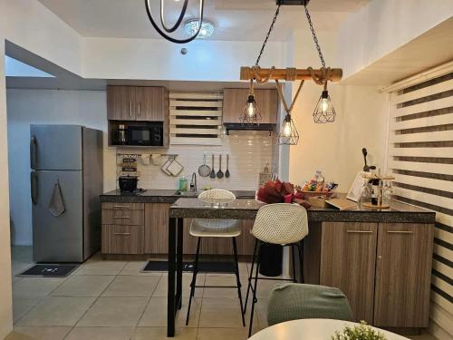 a kitchen with a refrigerator and a table and chairs at RDC Cozy Suite in Tagaytay