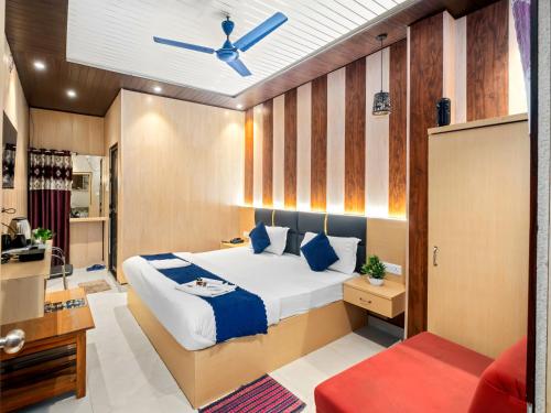 a bedroom with a bed and a ceiling fan at Hotel Ramay Palace in Ayodhya