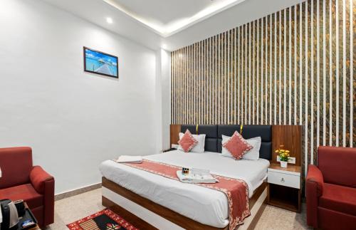 a hotel room with a bed and two chairs at Hotel Ramay Palace in Ayodhya