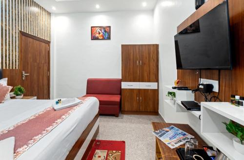 a hotel room with a bed and a red chair at Hotel Ramay Palace in Ayodhya