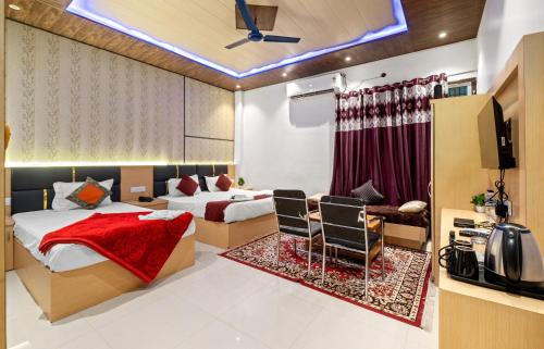 a hotel room with two beds and a television at Hotel Ramay Palace in Ayodhya