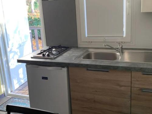 eine Küche mit Spüle und Herd in der Unterkunft Mobil-home avec terrasse, 2 chambres, Limeuil - API-1-52-330 in Limeuil