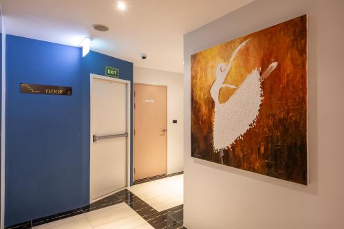 a painting on a wall in a hallway with a elevator at Stay Collection Nimman Chiangmai in Chiang Mai