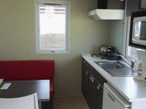 una piccola cucina con un lavandino e una finestra di Mobil-home avec Terrasse pour 2 Personnes - API-1-52-377 a Saint-Michel-Chef-Chef