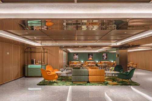a lobby with chairs and tables in a building at Orange Hotel Beijing Xi'erqi in Beijing
