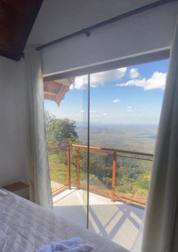 a bedroom with a bed and a large window at Chalé meu sonho 