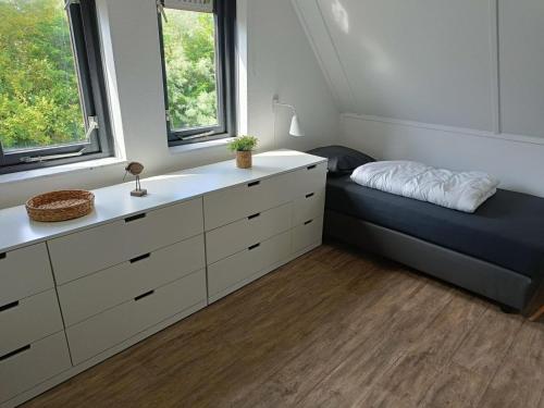 Un dormitorio con una cama y una cómoda. en Bungalow in Breskens near the Coast, en Breskens