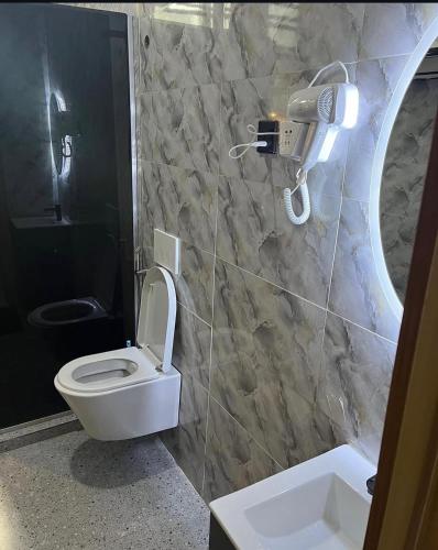 a bathroom with a toilet and a camera on the wall at Lush Homes 